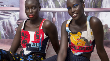 image of two models seated, looking at camera. text on shirts reads "all our children"